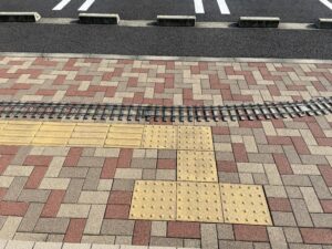 ミニSLの線路を敷いた写真。点字ブロックを目印に線路の位置を決めている。