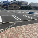 ミニSLの線路を敷いた写真。駐車場の車止めブロックを一つ外して線路を通している。